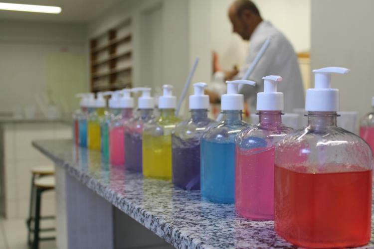 Imagem que apresenta um laboratório de química com uma bancada contendo vários recipentes com líquidos coloridos